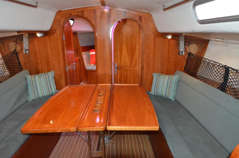 Slide: The Image of Interior of 1998 J Boats J/120 sailboat with wooden table and cushioned seating. - 33