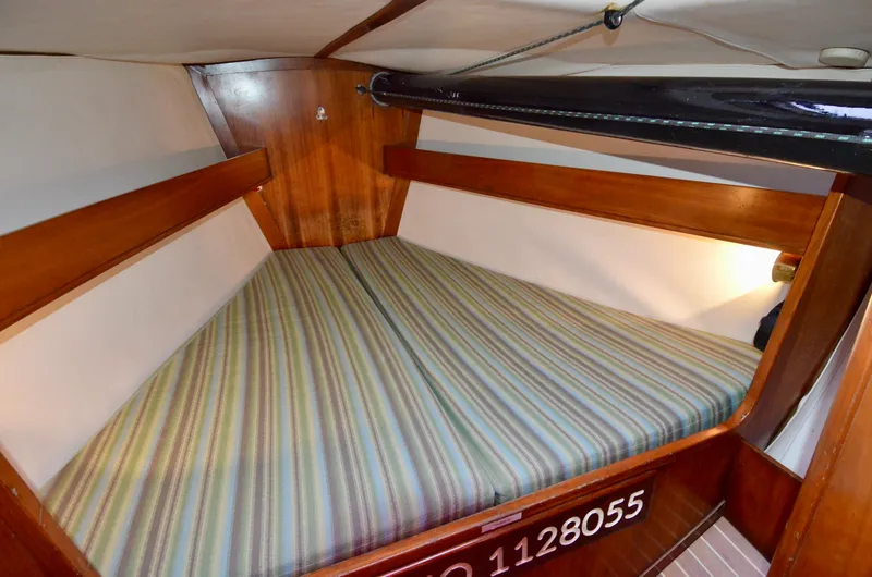 Slide: The Image of 1998 J Boats J/120 cabin with striped bedding and wooden interior. - 37