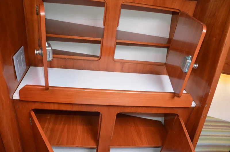 Slide: The Image of 1998 J Boats J/120 interior wooden cabinets with open doors, showcasing ample storage space. - 39