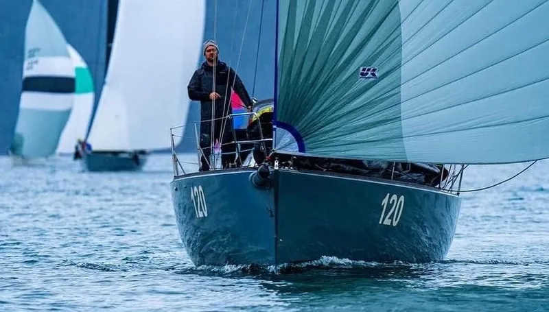 Slide: The Image of Sailing yacht J/120 from 1998 on open water, with crew member visible. - 4