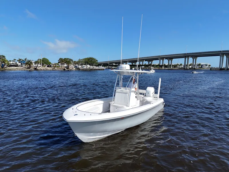 Slide: The Image of 2018 Contender 24 Sport boat on calm water near a bridge under clear blue sky. - 4