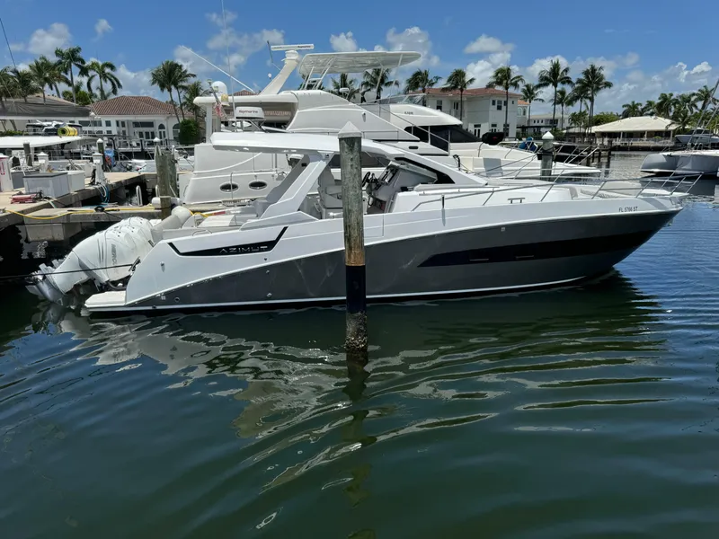 The Image of 2019 Azimut Verve 40 yacht docked in a marina, surrounded by palm trees. - 0
