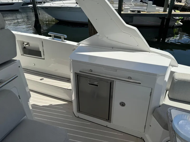 Slide: The Image of 2019 Azimut Verve 40 yacht interior with sleek cabinetry and seating at a marina. - 19