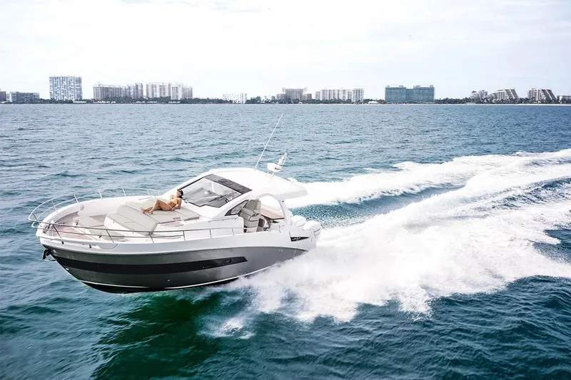 Slide: The Image of 2019 Azimut Verve 40 yacht cruising on open water, cityscape in background. - 6