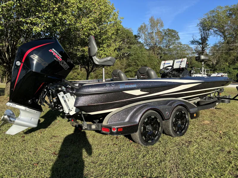 Slide: The Image of 2016 Triton 21 TrX Patriot boat with powerful outboard motor on grassy area. - 12