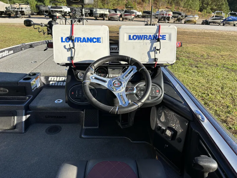 Slide: The Image of 2016 Triton 21 TrX Patriot boat dashboard with dual Lowrance HDS displays and steering wheel. - 16