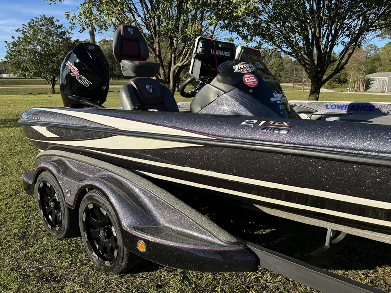 Slide: The Image of 2016 Triton 21 TrX Patriot boat on grass, featuring sleek design and modern equipment. - 3