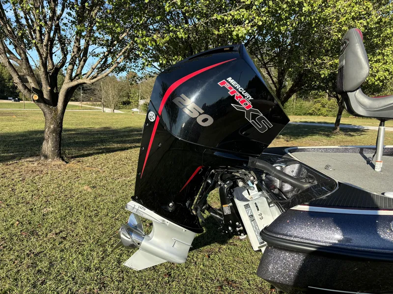 Slide: The Image of 2016 Triton 21 TrX Patriot with Mercury Pro XS engine in a grassy outdoor setting. - 5