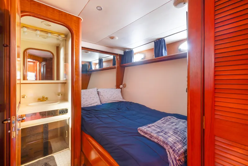 Slide: The Image of Cozy bedroom in 1989 Viking 63 Motor Yacht with wooden accents and blue bedding. - 31