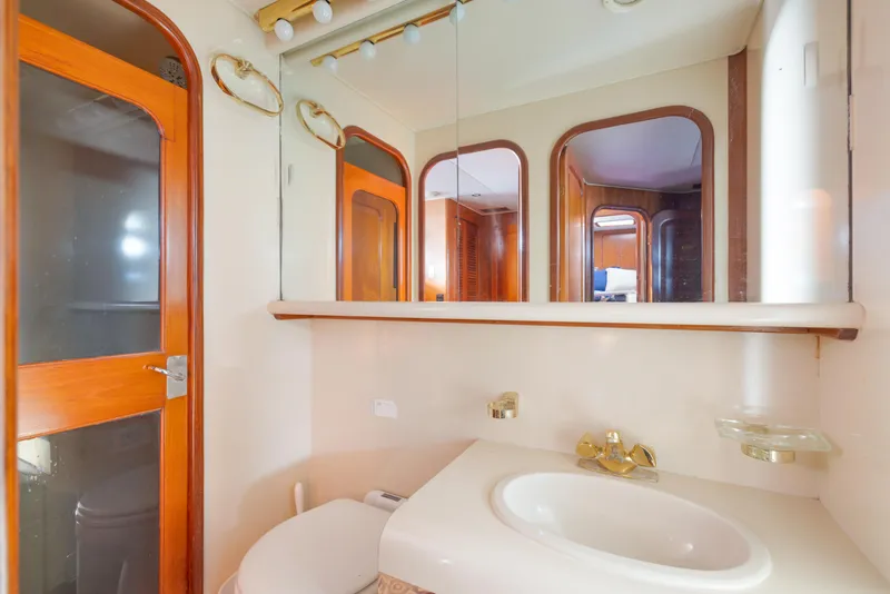 Slide: The Image of Bathroom interior of 1989 Viking 63 Motor Yacht with wooden accents and mirror. - 33