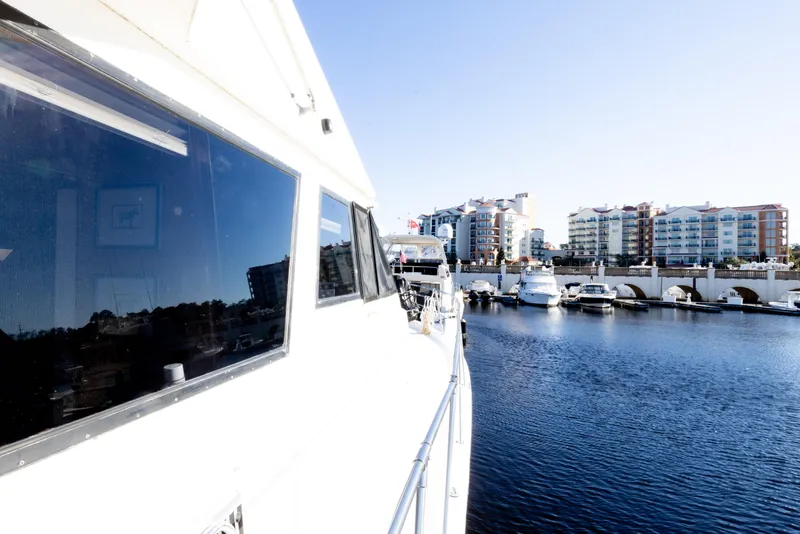 Slide: The Image of 1989 Viking 63 Motor Yacht docked in a marina with waterfront buildings. - 45