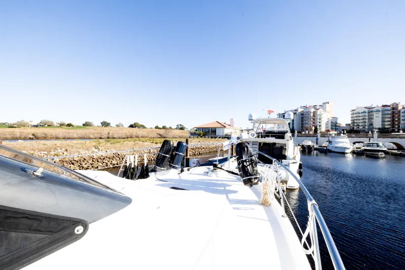 Slide: The Image of 1989 Viking 63 Motor Yacht docked in a marina with clear blue skies. - 46