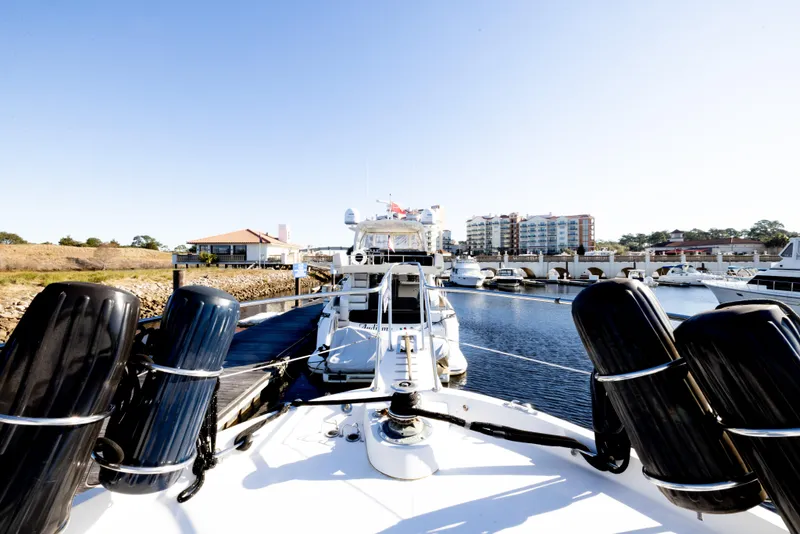 Slide: The Image of 1989 Viking 63 Motor Yacht docked in a marina with clear blue skies. - 47