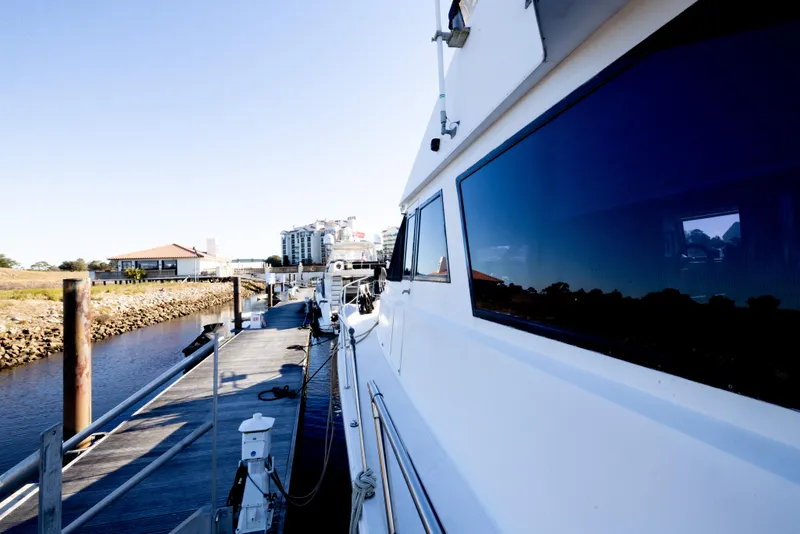 Slide: The Image of 1989 Viking 63 Motor Yacht docked at marina, side view with clear blue sky. - 49