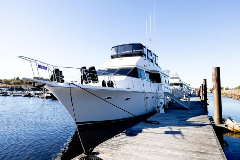Slide: The Image of 1989 Viking 63 Motor Yacht docked at marina under clear blue sky. - 50