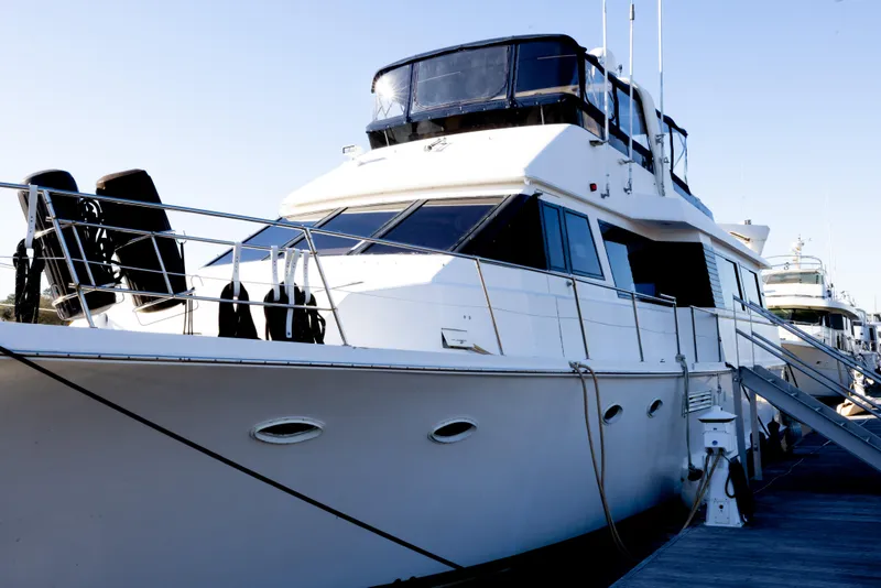 Slide: The Image of 1989 Viking 63 Motor Yacht docked, showcasing sleek design and spacious upper deck. - 51