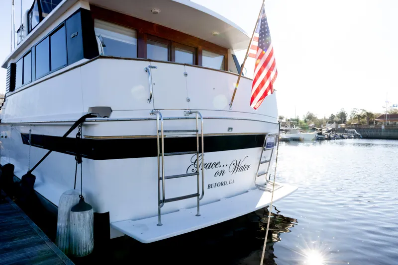 Slide: The Image of 1989 Viking 63 Motor Yacht docked with American flag, rear view. - 52