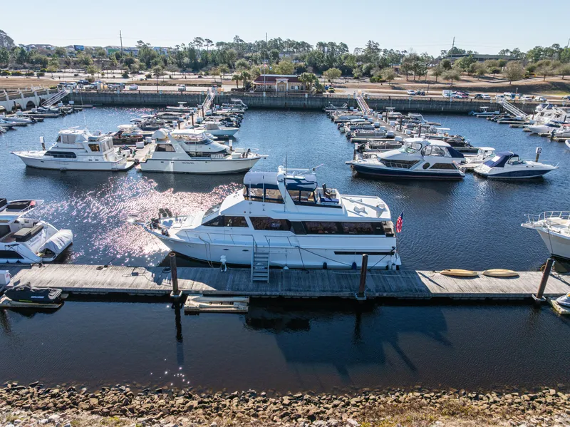 Slide: The Image of 1989 Viking 63 Motor Yacht docked in a marina, surrounded by other boats. - 6
