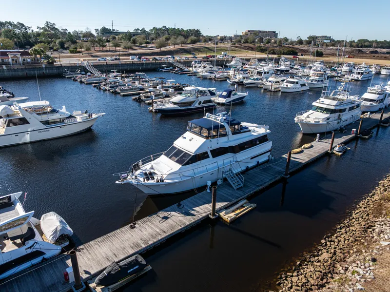 Slide: The Image of 1989 Viking 63 Motor Yacht docked in a marina with other boats. - 7