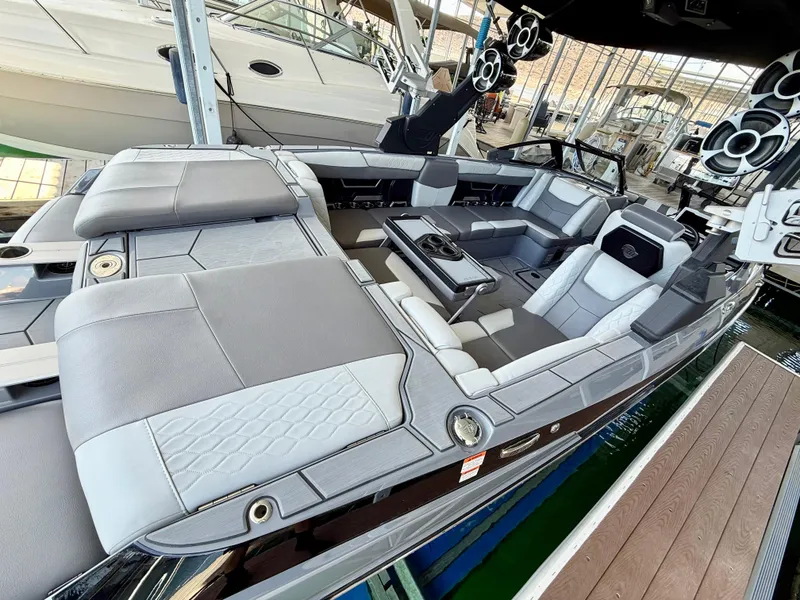 Slide: The Image of 2021 Malibu M240 boat with luxurious seating and modern design in a marina setting. - 13
