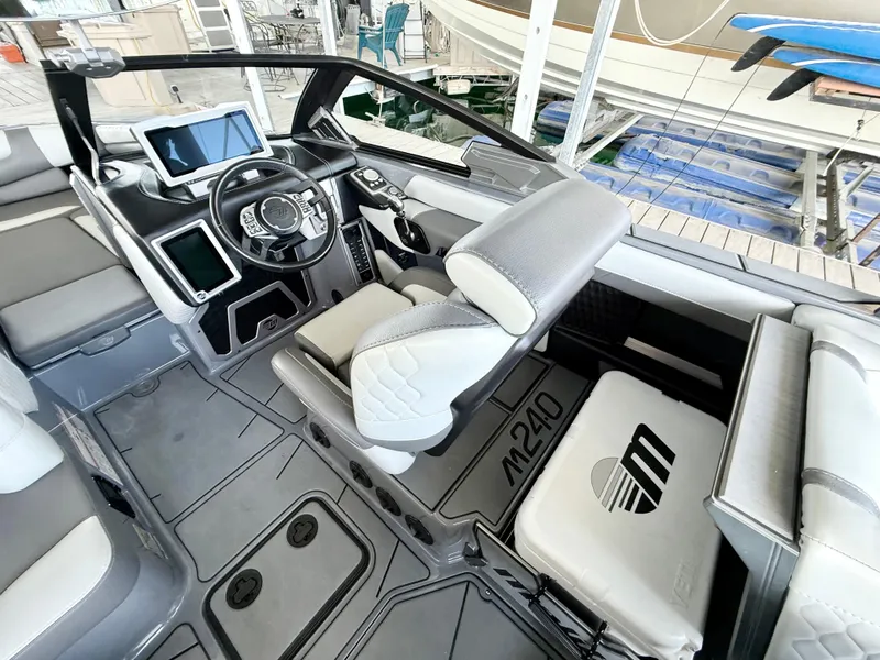 Slide: The Image of Interior of 2021 Malibu M240 boat with modern dashboard and seating. - 23