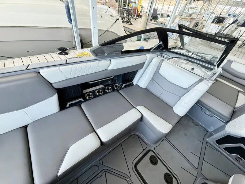 Slide: The Image of 2021 Malibu M240 boat interior with gray and white seating, showcasing luxury and comfort. - 24