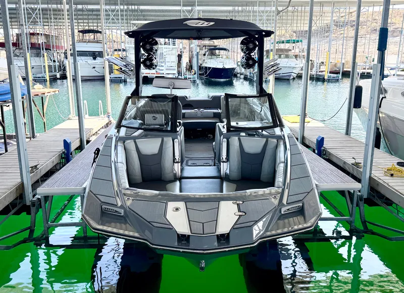 Slide: The Image of 2021 Malibu M240 boat docked in a marina, showcasing sleek design and spacious interior. - 3