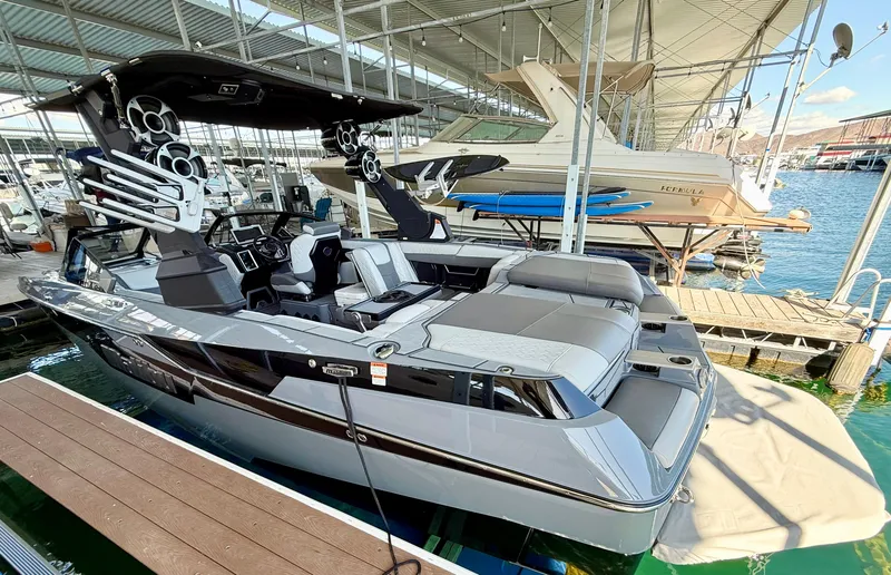 Slide: The Image of 2021 Malibu M240 boat docked in marina, featuring sleek design and modern amenities. - 4