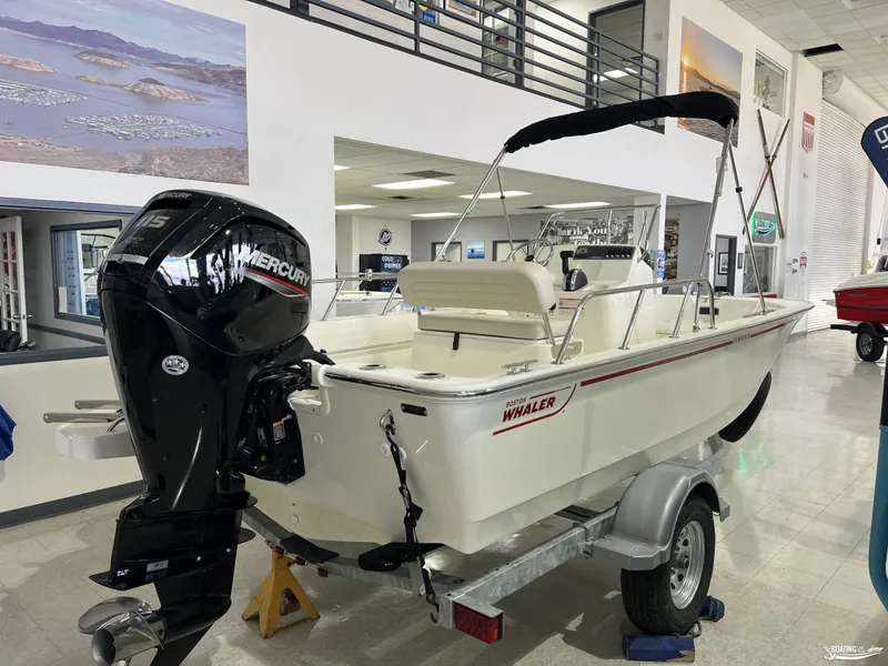 Slide: The Image of 2025 Boston Whaler 170 Montauk boat with Mercury engine displayed indoors. - 3