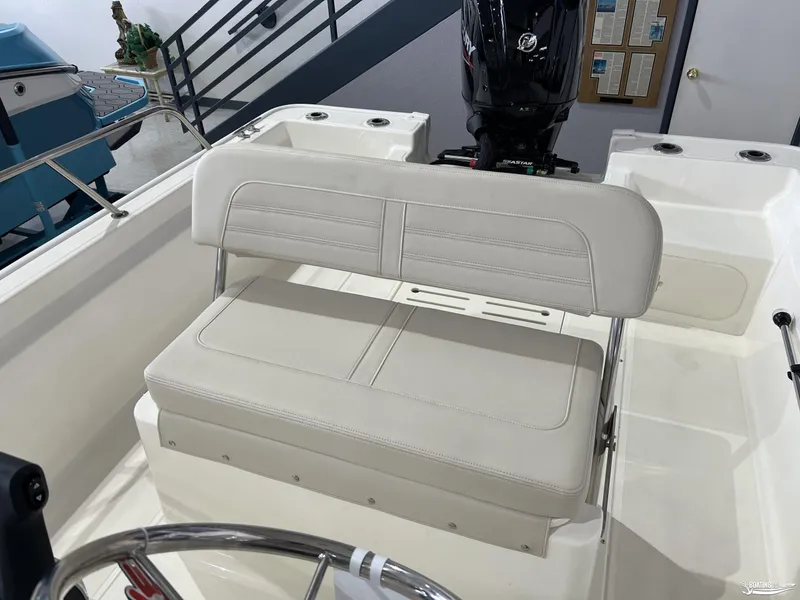 Slide: The Image of 2025 Boston Whaler 170 Montauk boat interior with cushioned seating and motor. - 6