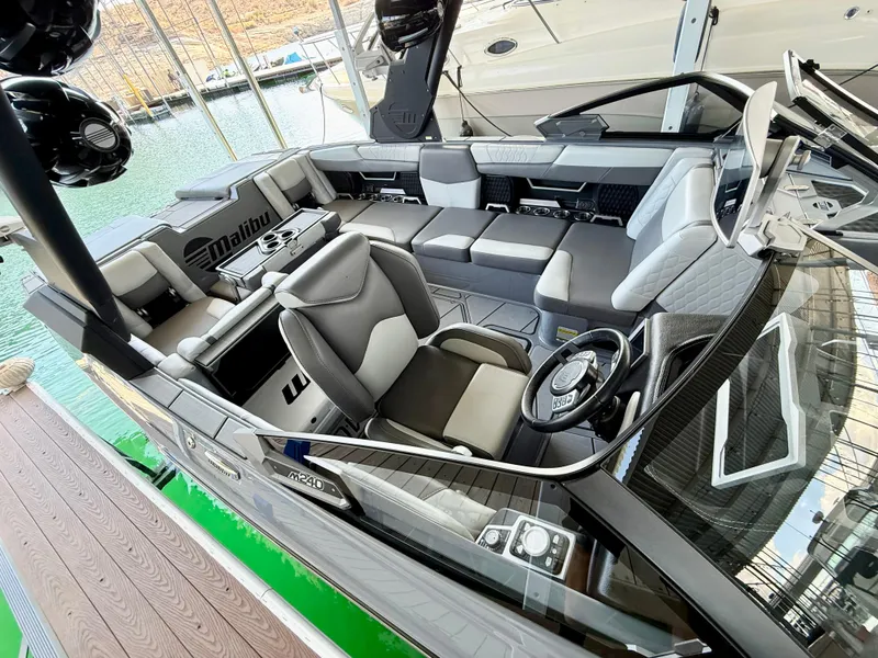 Slide: The Image of 2021 Malibu M240 boat interior with luxurious seating and modern dashboard. - 12