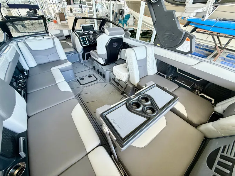 Slide: The Image of 2021 Malibu M240 boat interior with luxurious seating and modern dashboard. - 18