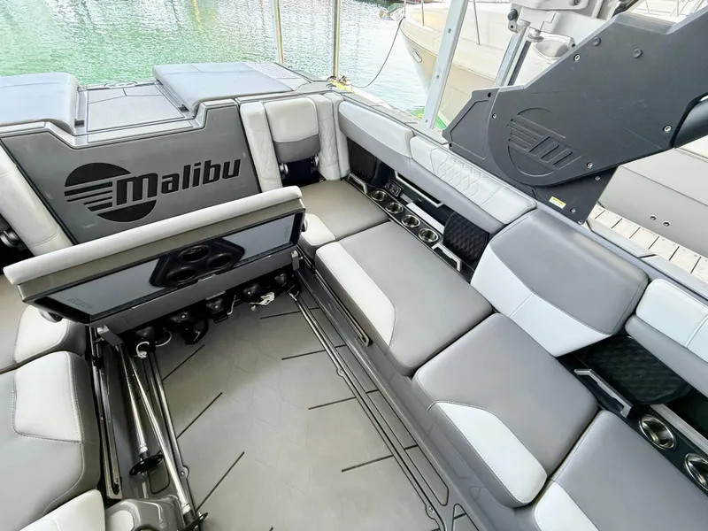 Slide: The Image of 2021 Malibu M240 boat interior with gray seating and logo. - 20