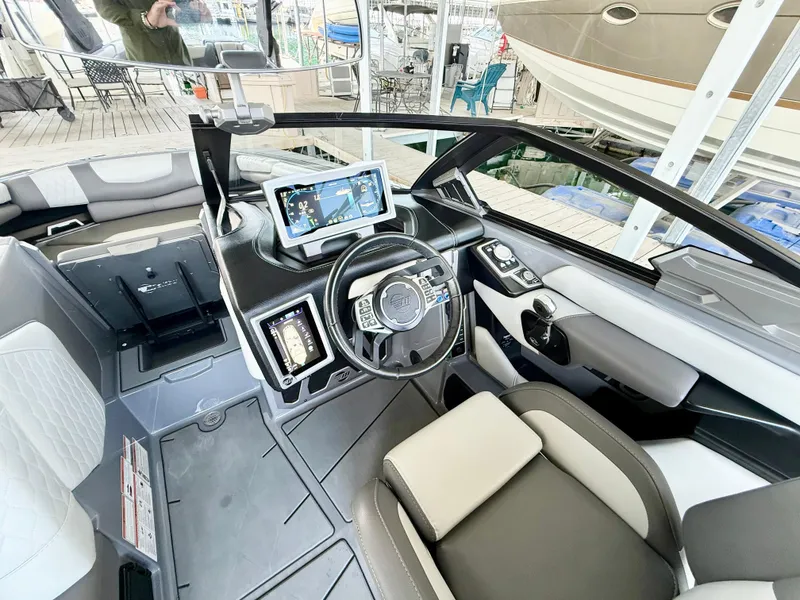 Slide: The Image of Interior of a 2021 Malibu M240 boat with modern dashboard and steering wheel. - 25