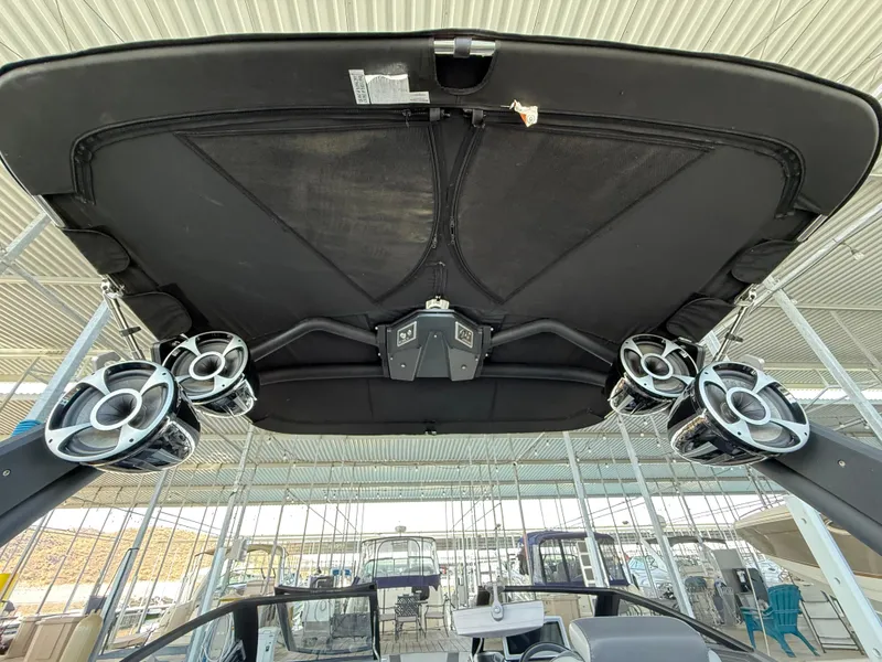 Slide: The Image of 2021 Malibu M240 boat with advanced audio system and sleek design under a canopy. - 32
