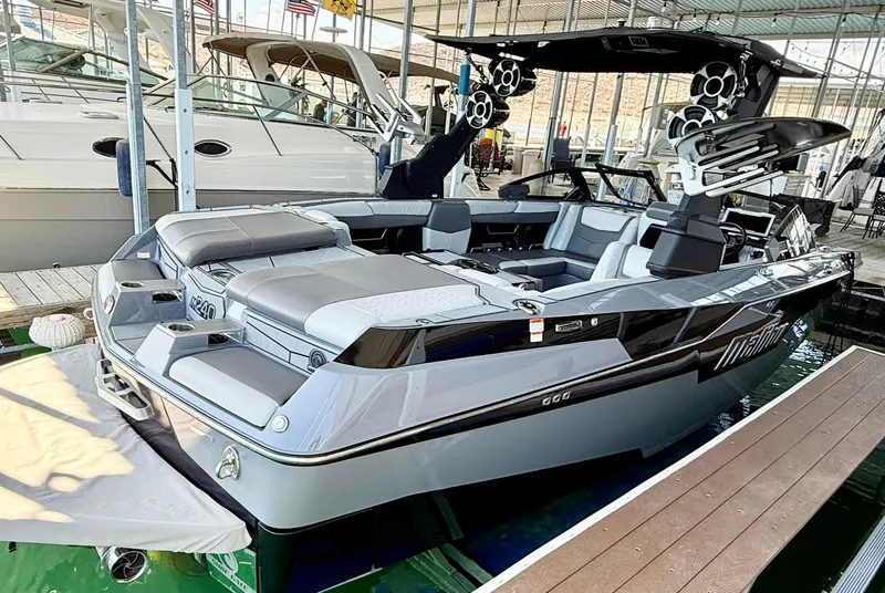 Slide: The Image of 2021 Malibu M240 boat docked, featuring sleek design and spacious seating. - 5