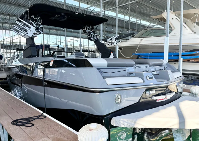 Slide: The Image of 2021 Malibu M240 boat docked in a marina, featuring sleek design and modern amenities. - 7