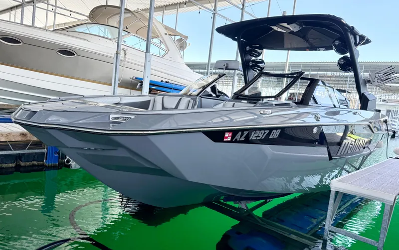 Slide: The Image of 2021 Malibu M240 boat docked in a marina, featuring sleek design and modern amenities. - 8