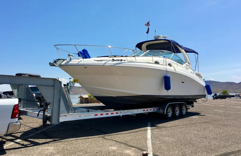 Slide: The Image of 2004 Sea Ray 340 Sundancer yacht on trailer in sunny parking lot. - 1