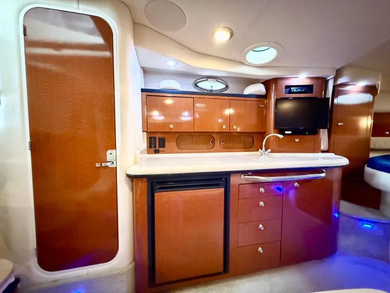 Slide: The Image of 2004 Sea Ray 340 Sundancer interior with wood cabinetry and modern amenities. - 23