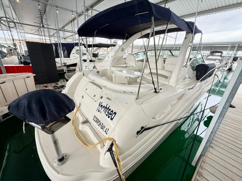 Slide: The Image of 2004 Sea Ray 340 Sundancer docked under a covered marina, featuring a sleek white design. - 3