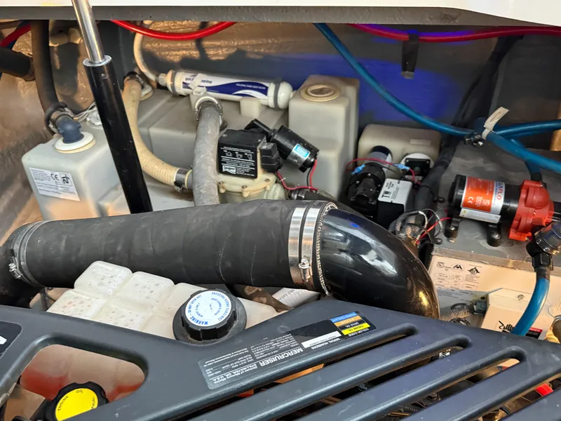 Slide: The Image of Engine compartment of a 2004 Sea Ray 340 Sundancer with visible hoses and components. - 34