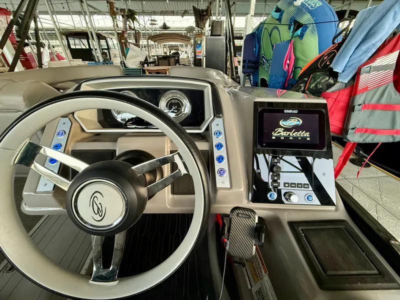 Slide: The Image of 2024 Barletta Corsa 23UC boat dashboard with steering wheel and control panel. - 15