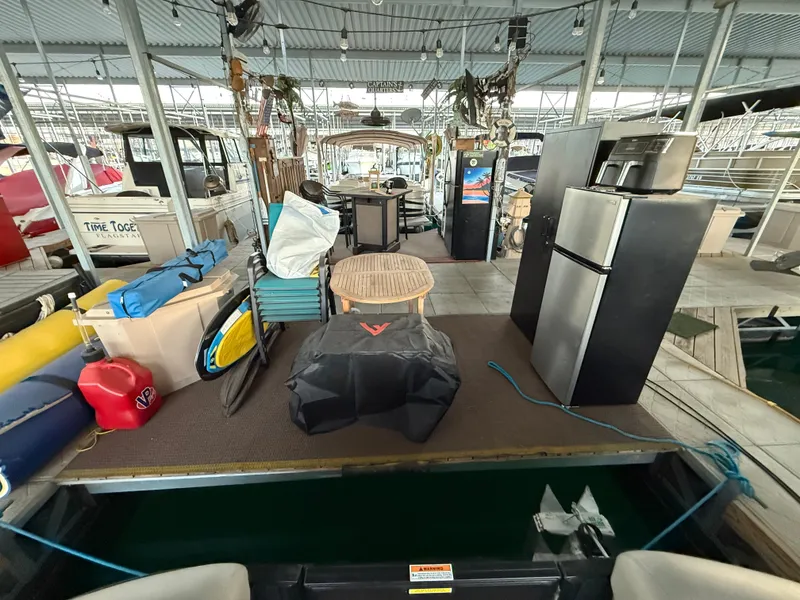 Slide: The Image of 2024 Barletta Corsa 23UC pontoon boat docked with outdoor gear and appliances. - 16