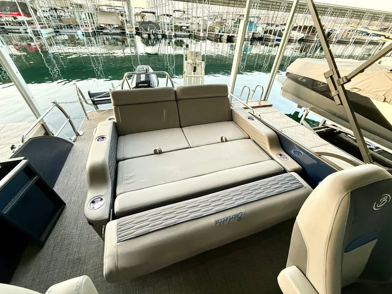 Slide: The Image of 2024 Barletta Corsa 23UC pontoon boat interior with convertible seating and lake view. - 3