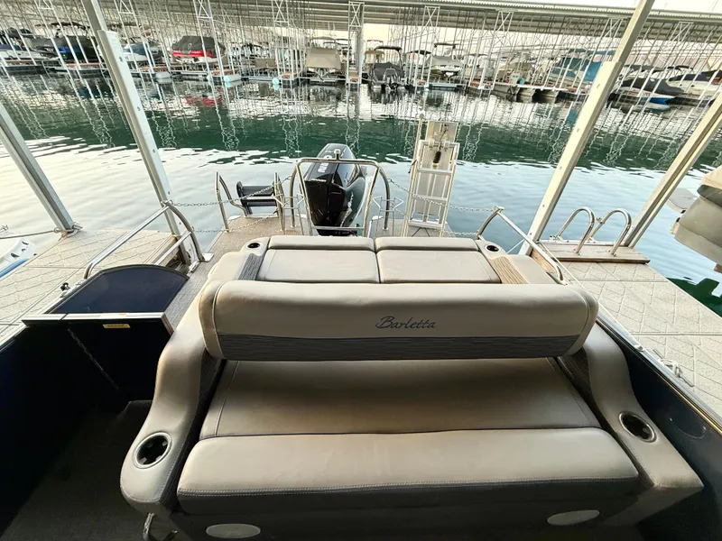 Slide: The Image of 2024 Barletta Corsa 23UC boat with comfortable seating, docked at a marina. - 5