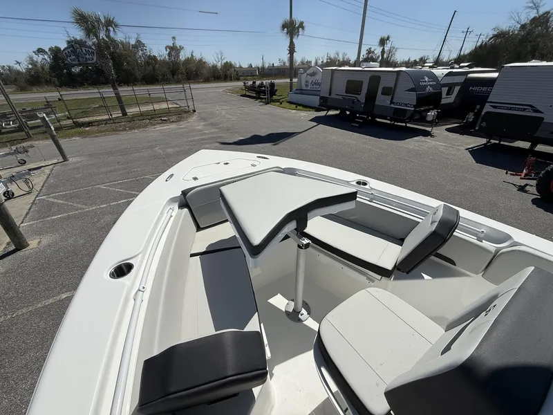 Slide: The Image of 2025 Sea Pro 225FLX SANDBAR boat interior with seating and table, parked near RVs. - 12