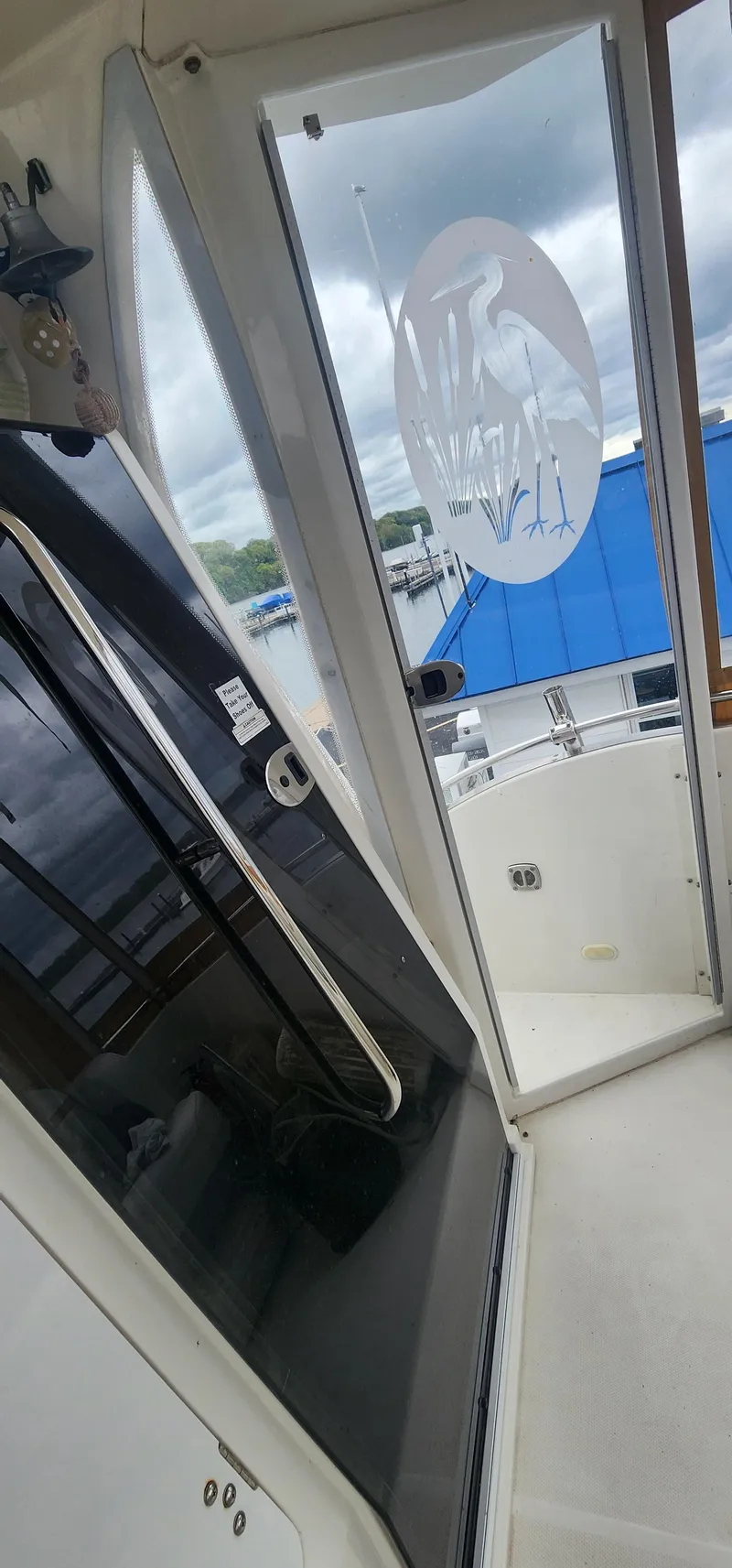 Slide: The Image of 2006 Carver 36 Aft Cabin Motor Yacht interior with open door and marina view. - 13
