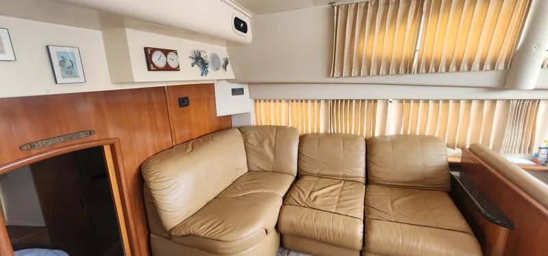 Slide: The Image of Interior of 2006 Carver 36 Aft Cabin Motor Yacht with beige leather sofa and wood paneling. - 16