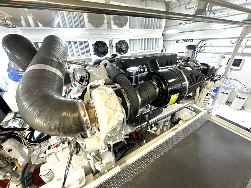 Slide: The Image of Engine room of 2008 Viking 64 Enclosed Bridge yacht, showcasing powerful machinery and components. - 18